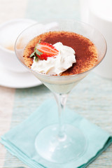 Tiramisu, traditional Italian dessert with strawberry Blue napkin