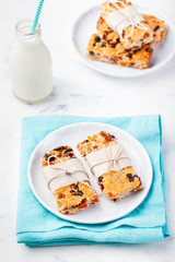 Granola, oatmeal, oat bars with dried cranberry and raisin on a white and blue background. Healthy breakfast