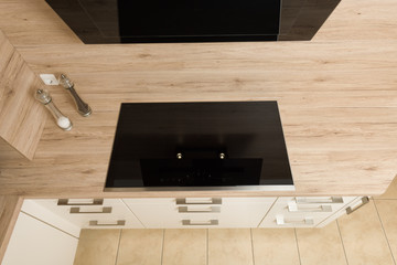 Top down view on modern induction hob with extractor hood above