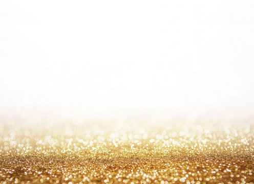 Abstract shining glitters gold holiday bokeh background with white copy space