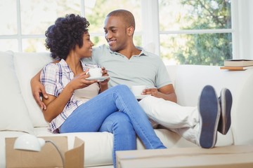 Happy couple on the sofa drinking coffee