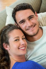 Portrait of young couple lying together on sofa