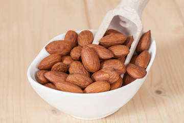 Almonds in bowl  on wood