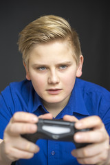 Single male child in blue using game controller