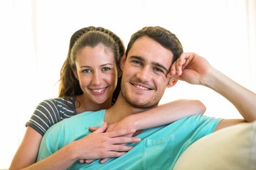 Portrait of young couple smiling on sofa