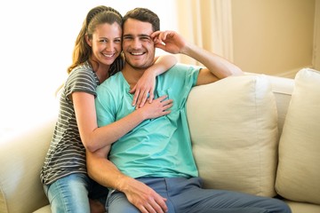 Portrait of young couple smiling and embracing