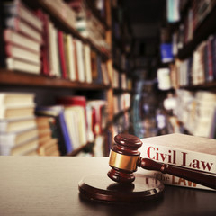 Wooden judges gavel and law books on table in library