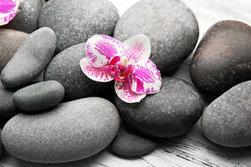 Naklejka na ściany i meble Spa stones and orchids on wooden background