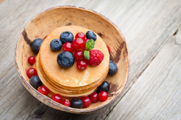 Stack of pancakes with blueberry and fresh berry.