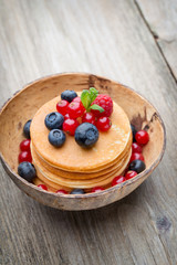Stack of pancakes with blueberry and fresh berry.