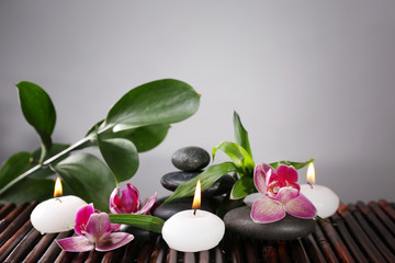 Spa still life with beautiful flower and candlelight on grey background