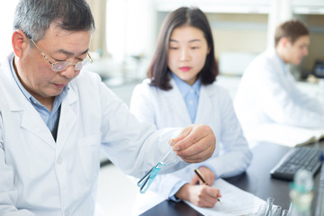 Fototapeta premium people doing chemical experiment in modern lab