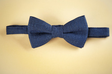 Dark blue bow tie on beige background