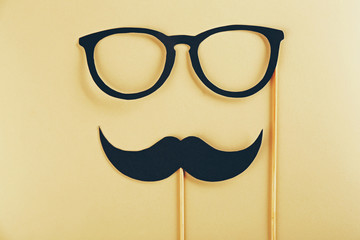 Photo booth props glasses, mustache on beige background