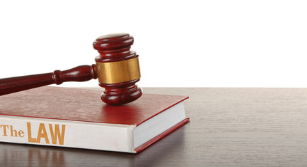 Gavel and book on wooden table on white background