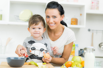 mutter schneidet mit sohn frisches obst