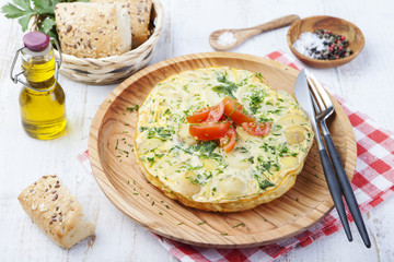 Omelet with potato from spain called tortilla de patatas on a white wooden background