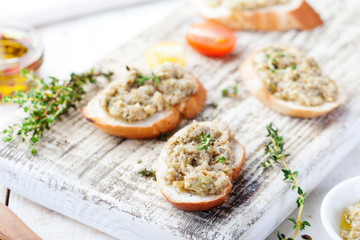 Bruschetta with green olives paste, tapenade on a white wooden background
