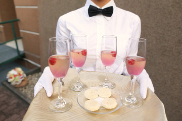 Waiter with glasses of champagne on tray