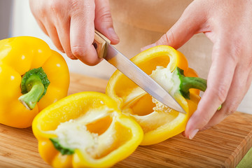 Woman cutting sweet yellow bell pepper