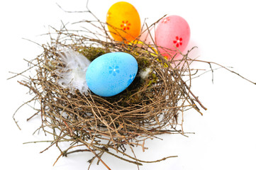 Colorful easter eggs in nest on a white background