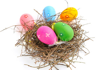 Colorful easter eggs in nest on a white background