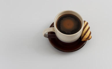 Cup of coffee and cookie on plate