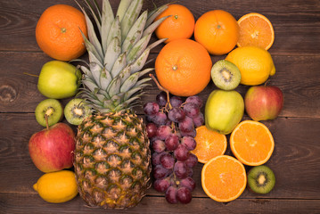 Naklejka na ściany i meble Tasty fruit background with orange, kiwi, grape, apples and lemon on the wooden table