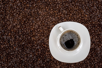 coffee beans background and white cup with hot drink