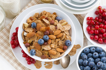breakfast with cereals flakes, nuts and berries, top view