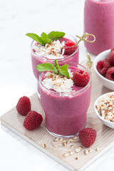 fresh berry smoothies with nuts on white board, vertical