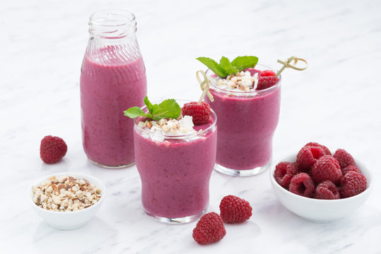 fresh berry smoothies with nuts on white table