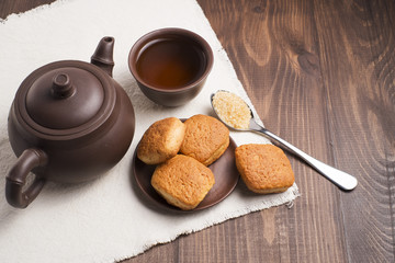 Square mug of tea with shortbread biscuits, on a brown table and a napkin