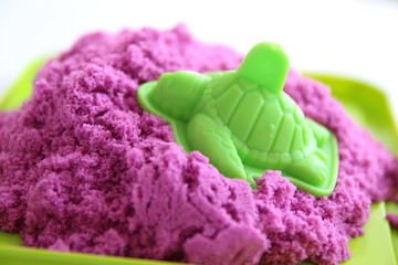 Fun kinetic sand. Purple kinetic sand with child toys, turtle for indoor children creativity games 