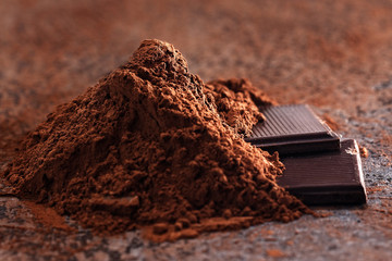Chocolate pieces with cocoa beans on a stone table