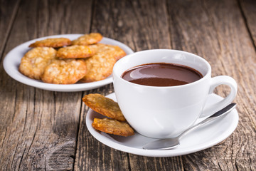 White cup of hot chocolate with homemade oat cookies.