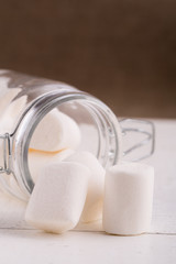 Fototapeta na wymiar Marshmallows spilling from a storage jar.