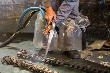 Worker is cleaning the machine equipment by using the air pressure sand / dryice blasting 