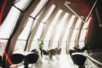 wedding couple is standing and kissing in hotel