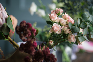 Florist workplace: flowers and accessories on a vintage wooden table. soft focus