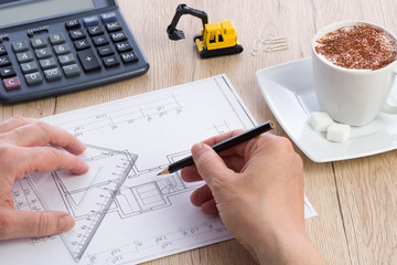 Close-up of architect hands working on a blueprint