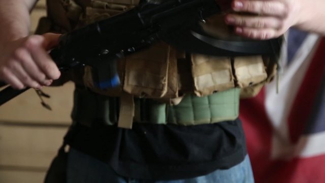 Man reloads his weapon close-up.