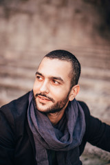 Stylish bearded man standing against of white wall and looking a