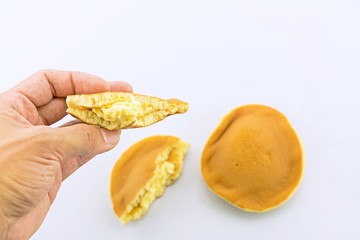 Close up of Dorayaki on hand, delicious sweets of Japanese Traditional Dessert : Dorayaki isolated on white

