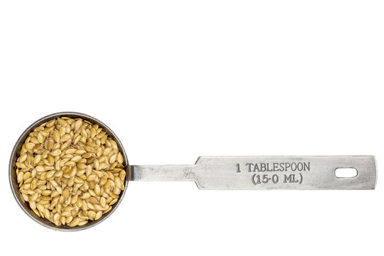 golden flax seeds in a tablespoon in a tablespoon