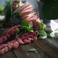 Florist workplace: flowers and accessories on a vintage wooden table. soft focus