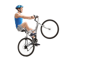 Naklejka premium Young cyclist performing a wheelie