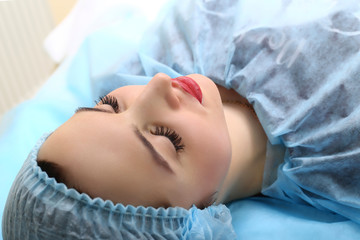 Cosmetologist making permanent makeup on woman's face