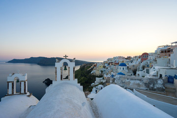 Evening scene in Santorini island with the top of the church and the night light of Oia village