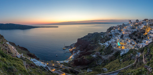 Evening scene in Santorini island with the night light of Oia village in panorama